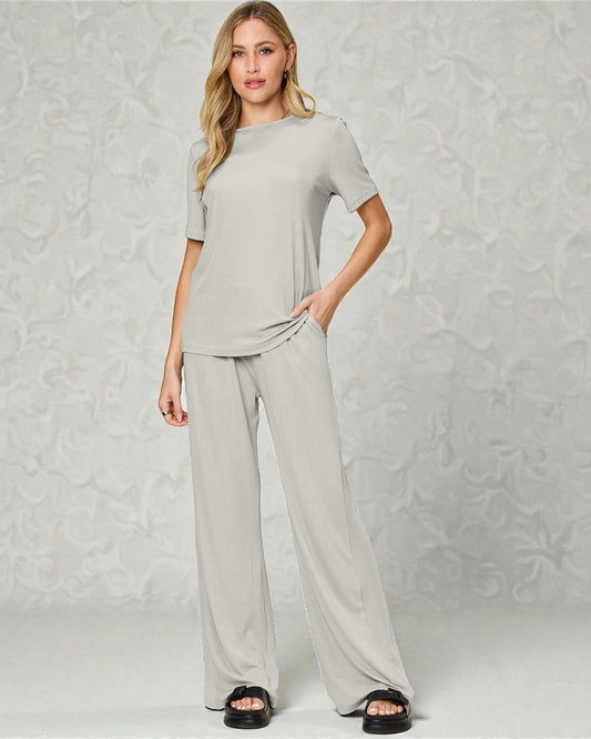 Woman wearing a gray outfit against a textured light gray background