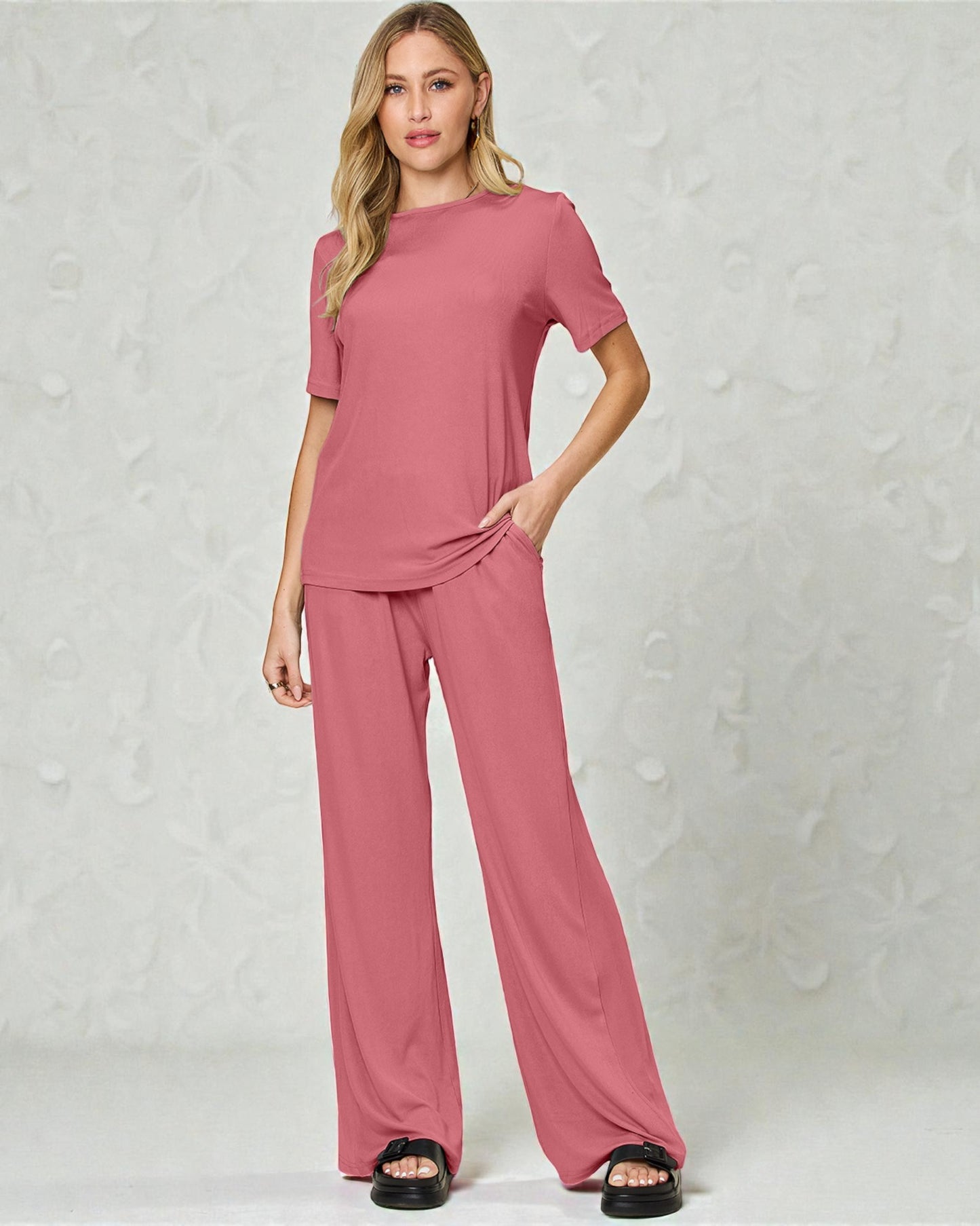 Woman wearing a pink outfit against a light gray background