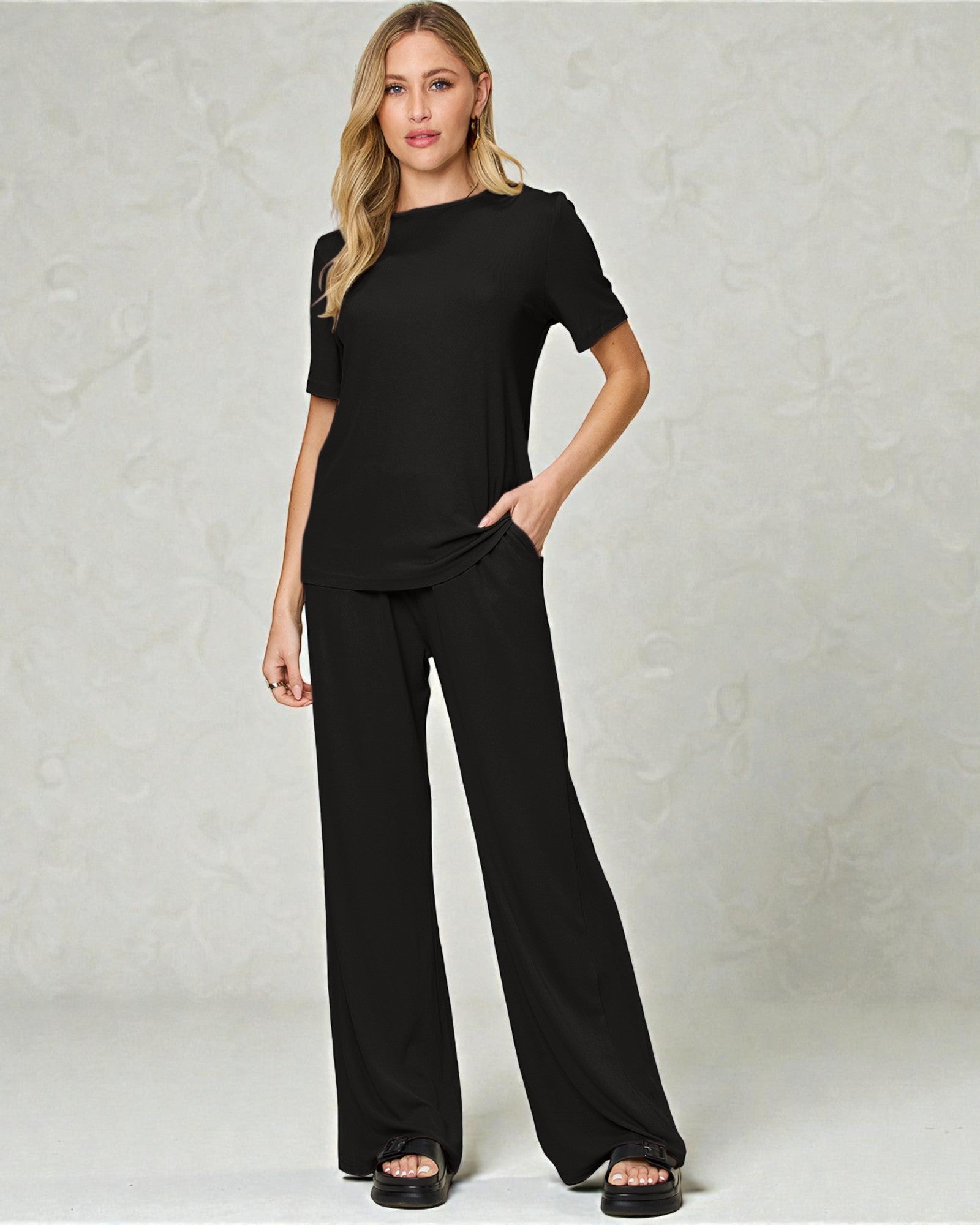Woman wearing a black outfit against a plain background