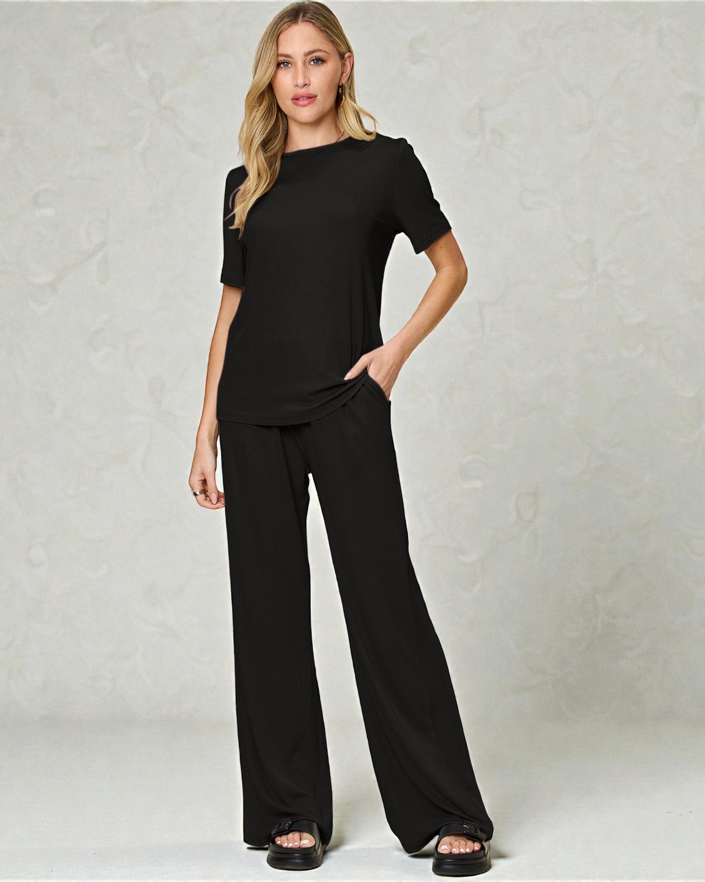 Woman wearing a black outfit against a plain background