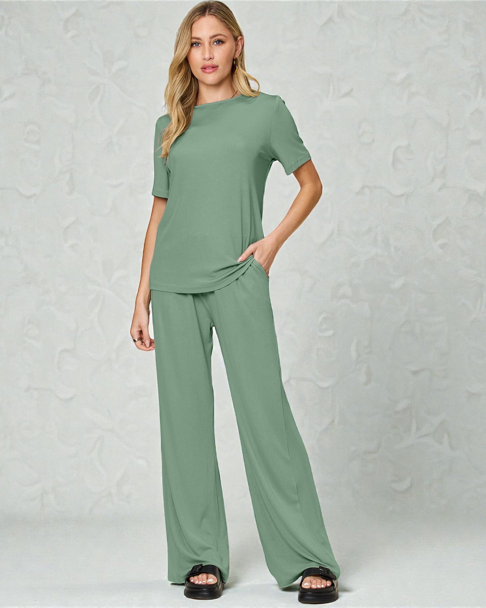 Woman wearing a green outfit against a plain background