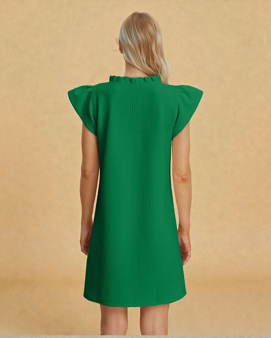 Green dress worn by a person on a beige background