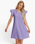 A woman modeling a lavender purple textured dress with ruffled trim at the neckline and cap sleeves, set against a plain white studio background.