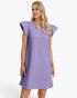 A woman modeling a lavender-purple textured nightgown with flutter sleeves and a ruffled V-neckline, photographed against a clean white studio background.