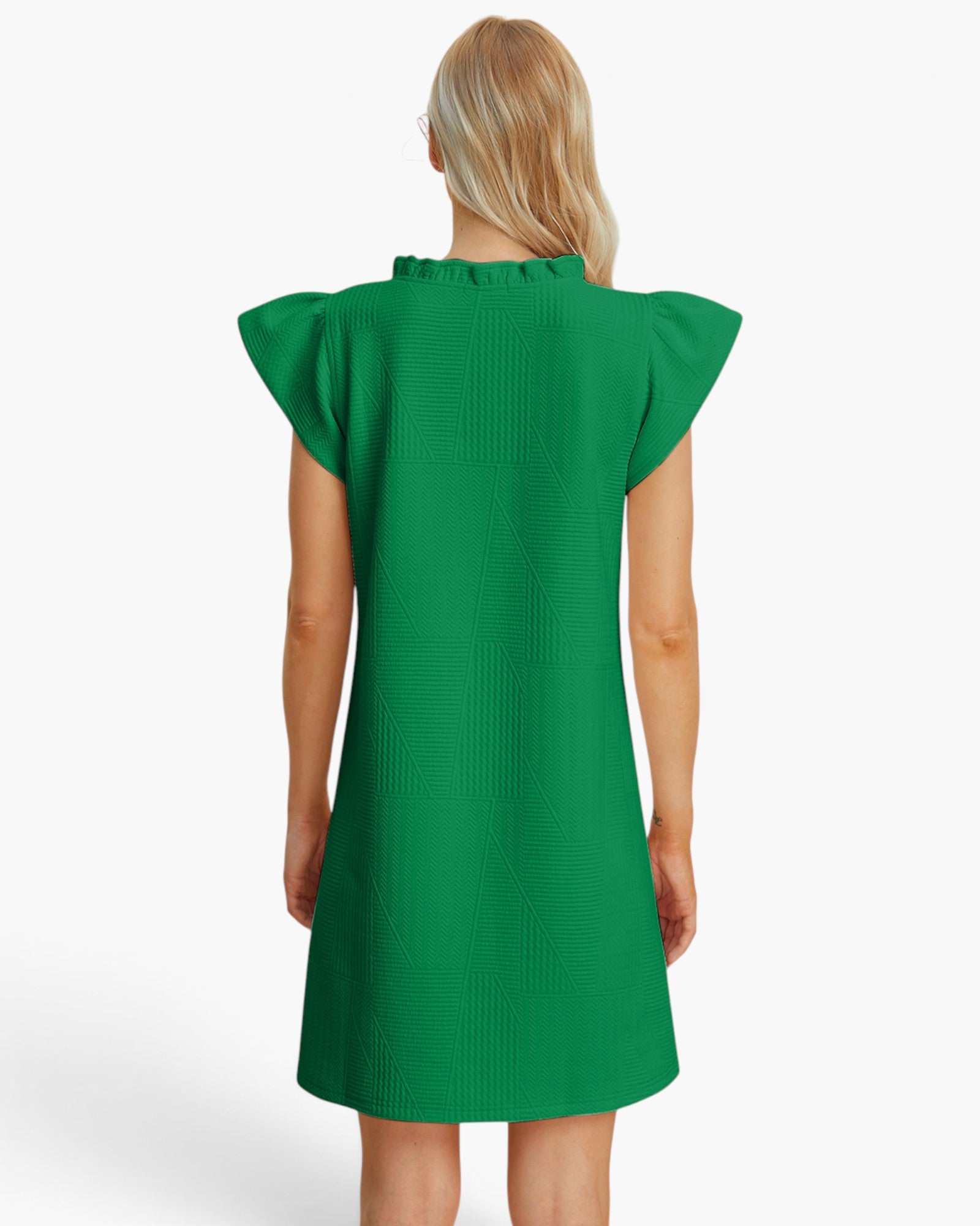 A woman viewed from the back wearing a bright green textured dress with ruffled cap sleeves and a ruffled neckline, against a clean white studio background.