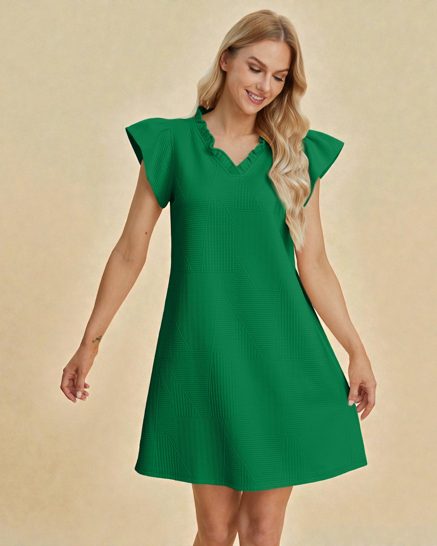 Woman wearing a green dress against a beige background