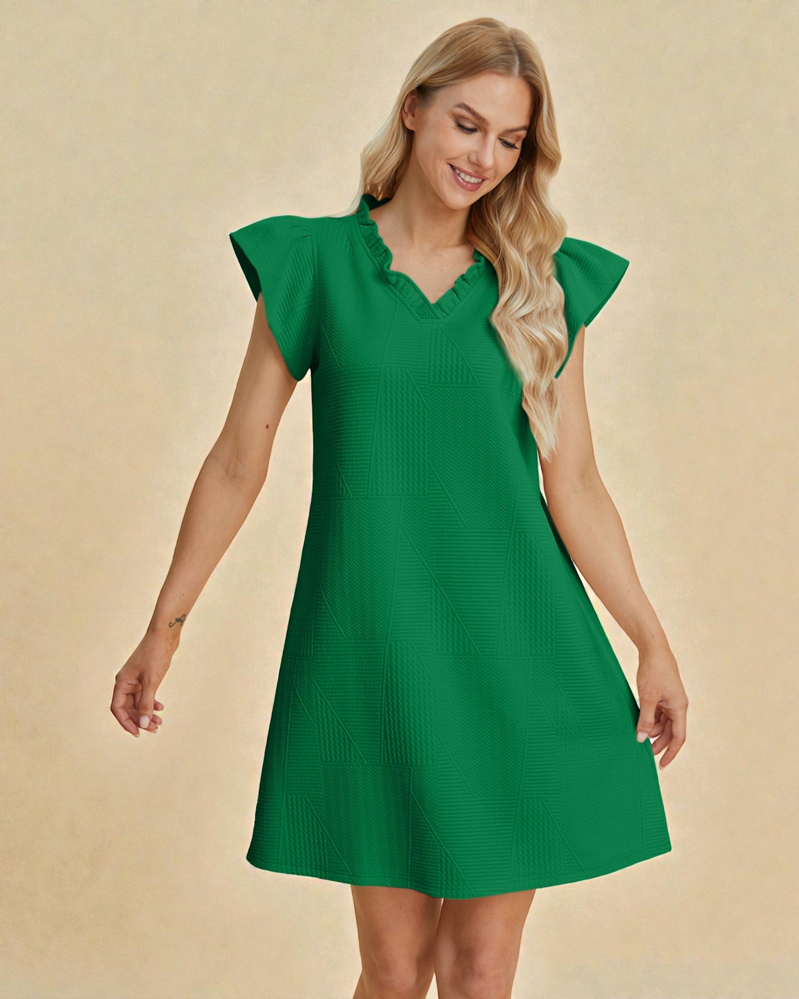 Woman wearing a green dress against a beige background