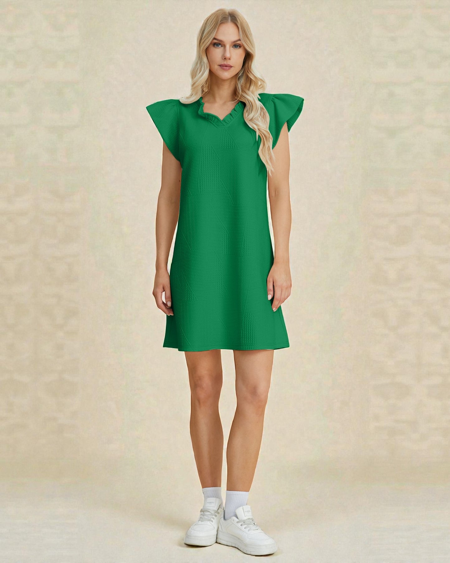Woman wearing a green dress against a beige background