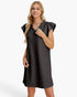 A woman modeling a black textured mini dress with ruffled cap sleeves and a split neckline, photographed against a clean white studio background.