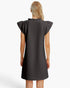 A woman viewed from the back wearing a dark charcoal gray textured dress with ruffled cap sleeves and a ruffled neckline, set against a plain white studio background.
