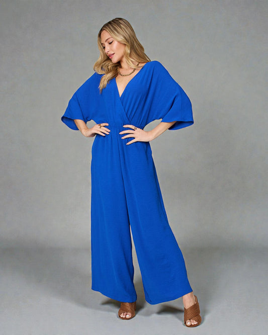Woman wearing a blue jumpsuit on a gray background