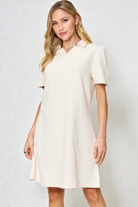 Woman wearing a white dress against a plain background