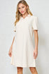 Woman wearing a white dress against a plain background