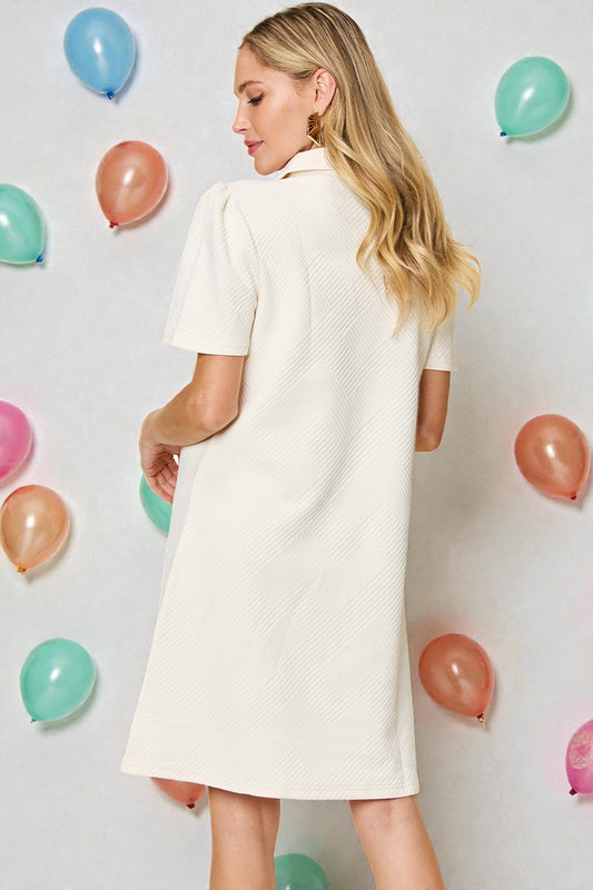 Woman in a white dress standing in front of colorful balloons on a light gray background