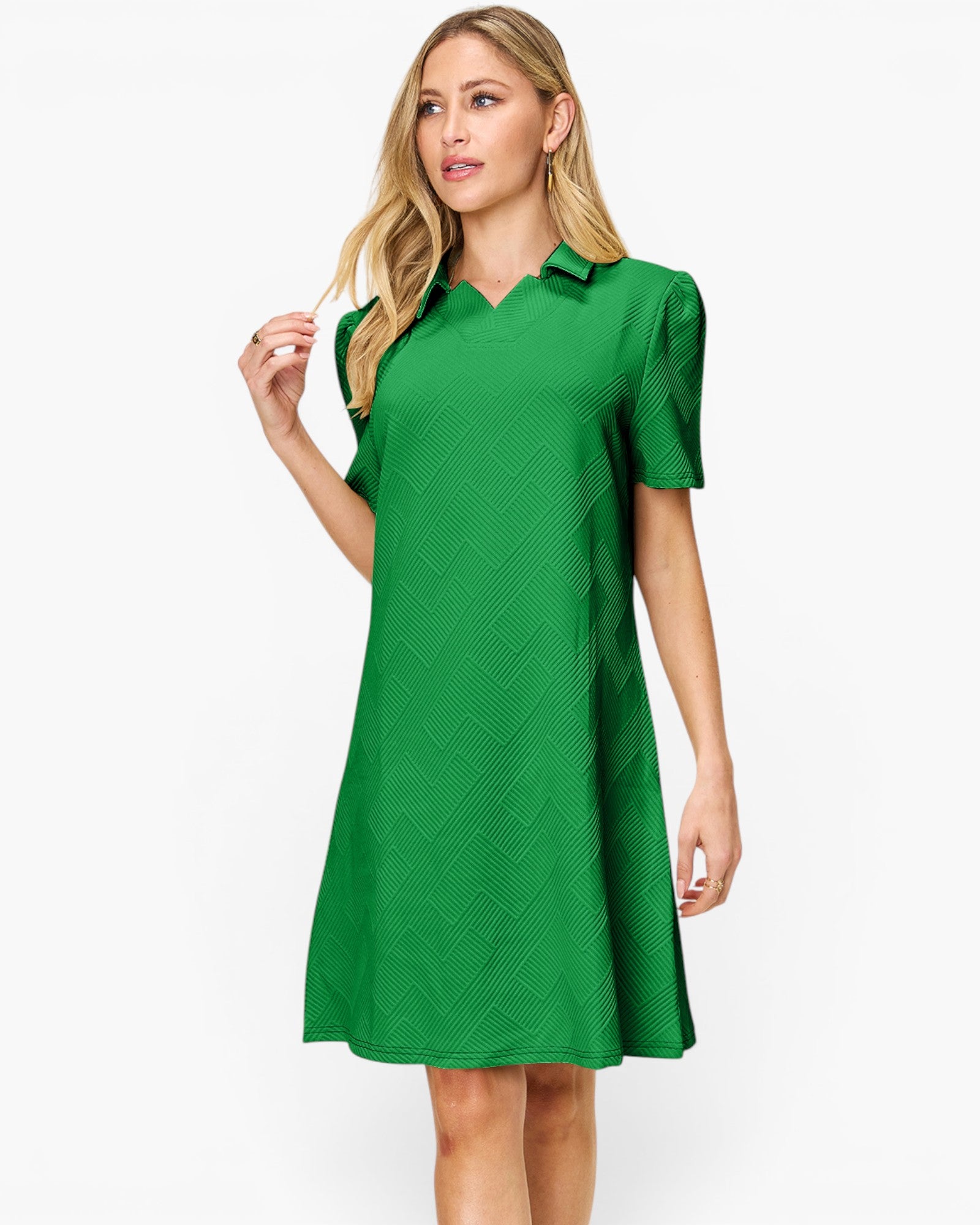 A woman modeling a bright green short-sleeve collared dress with a subtle textured pattern, set against a plain white studio background.