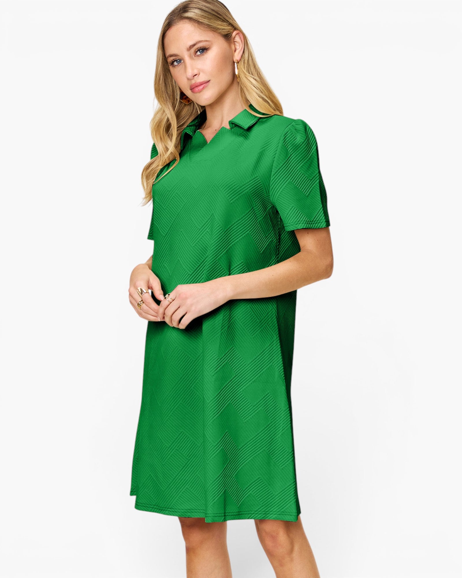 A woman modeling a bright green short-sleeve collared dress with a subtle textured pattern, set against a plain white studio background.