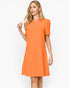 A woman modeling a bright orange short-sleeve polo dress against a plain white studio background.