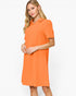 A woman modeling a short-sleeve collared shift dress in a bright orange color, photographed against a clean white studio background.