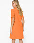 A woman modeling a bright orange short-sleeve dress from the back, shown against a plain white studio background.