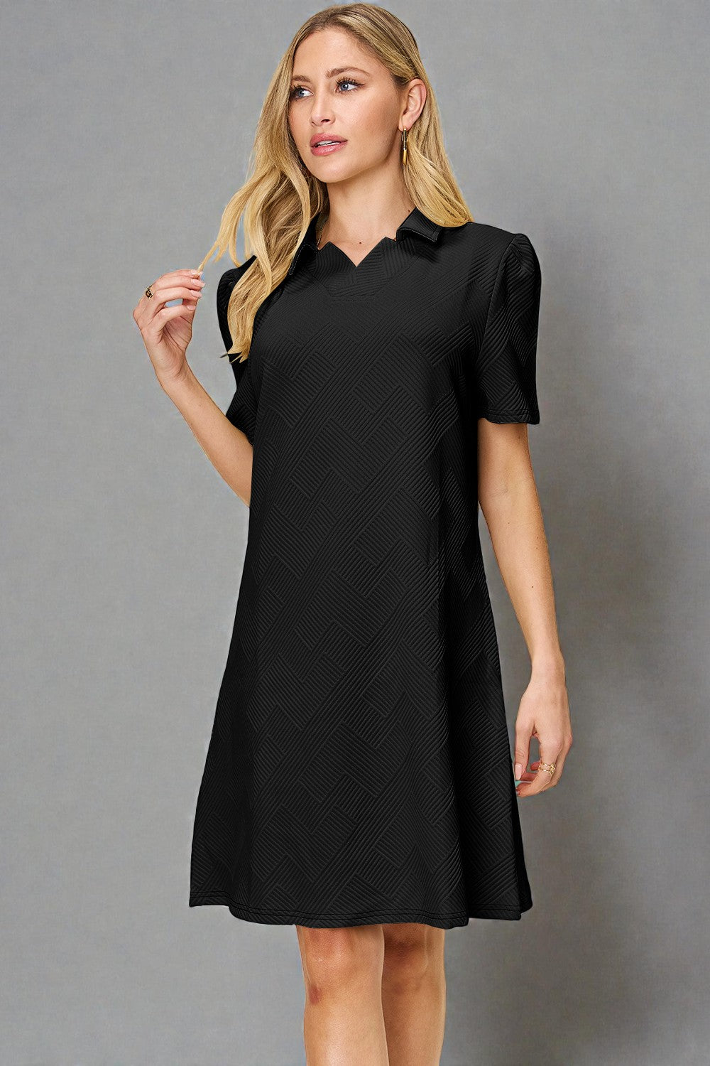 Woman wearing a black dress against a gray background