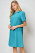 Woman wearing a teal dress against a plain background