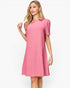 A woman modeling a pink short-sleeve collared dress with a subtle textured pattern, set against a plain white studio background.