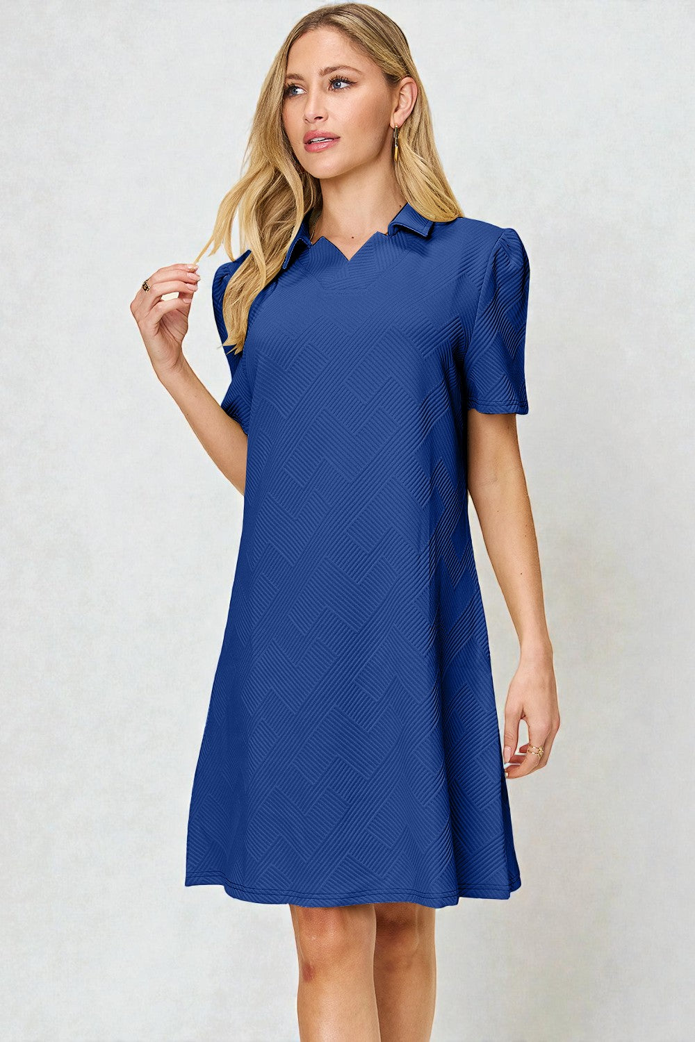 Woman wearing a blue dress against a light gray background