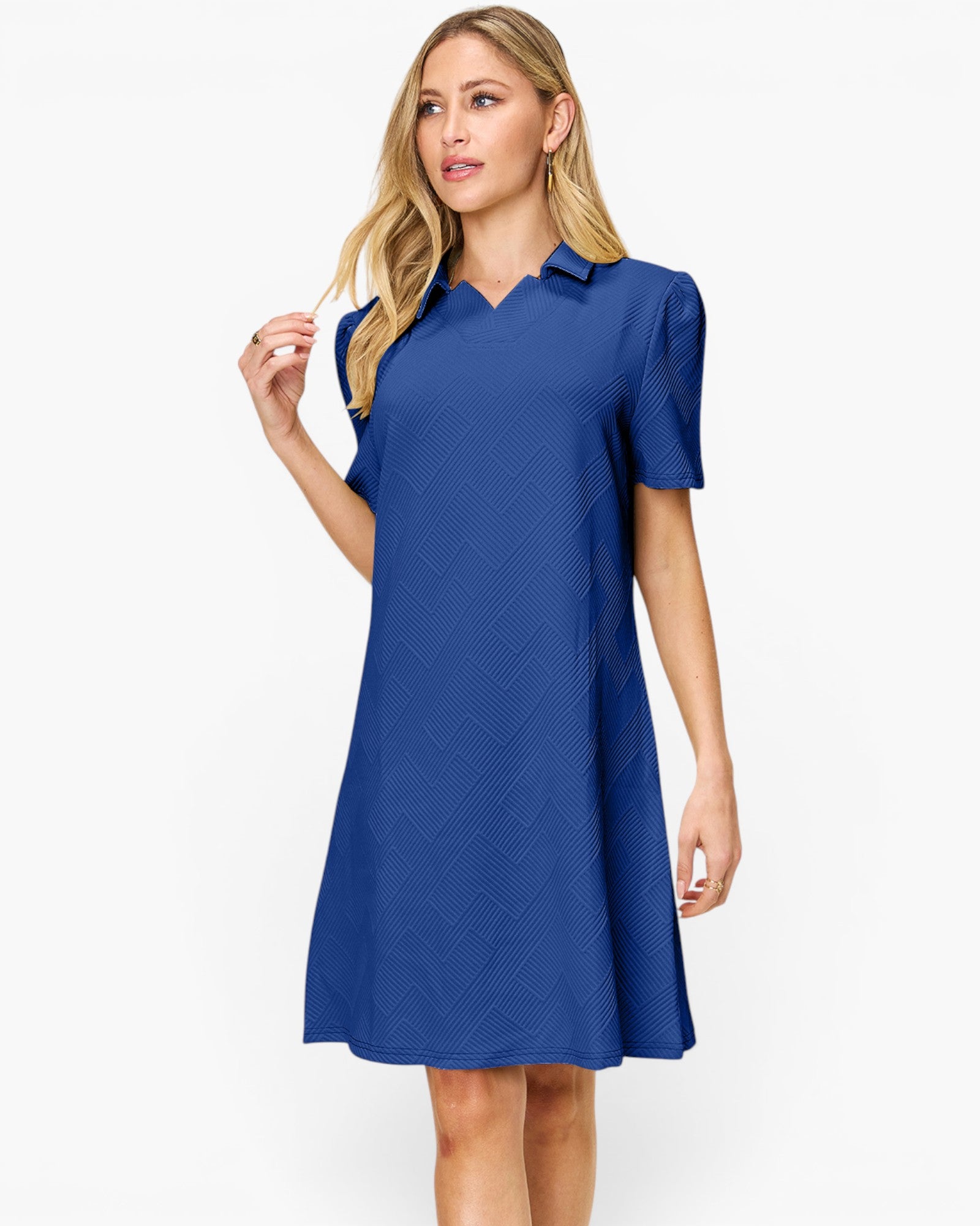 A woman modeling a royal blue short-sleeve collared shift dress with a subtle geometric texture, set against a plain white studio background.