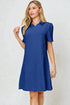Woman wearing a blue dress against a light gray background