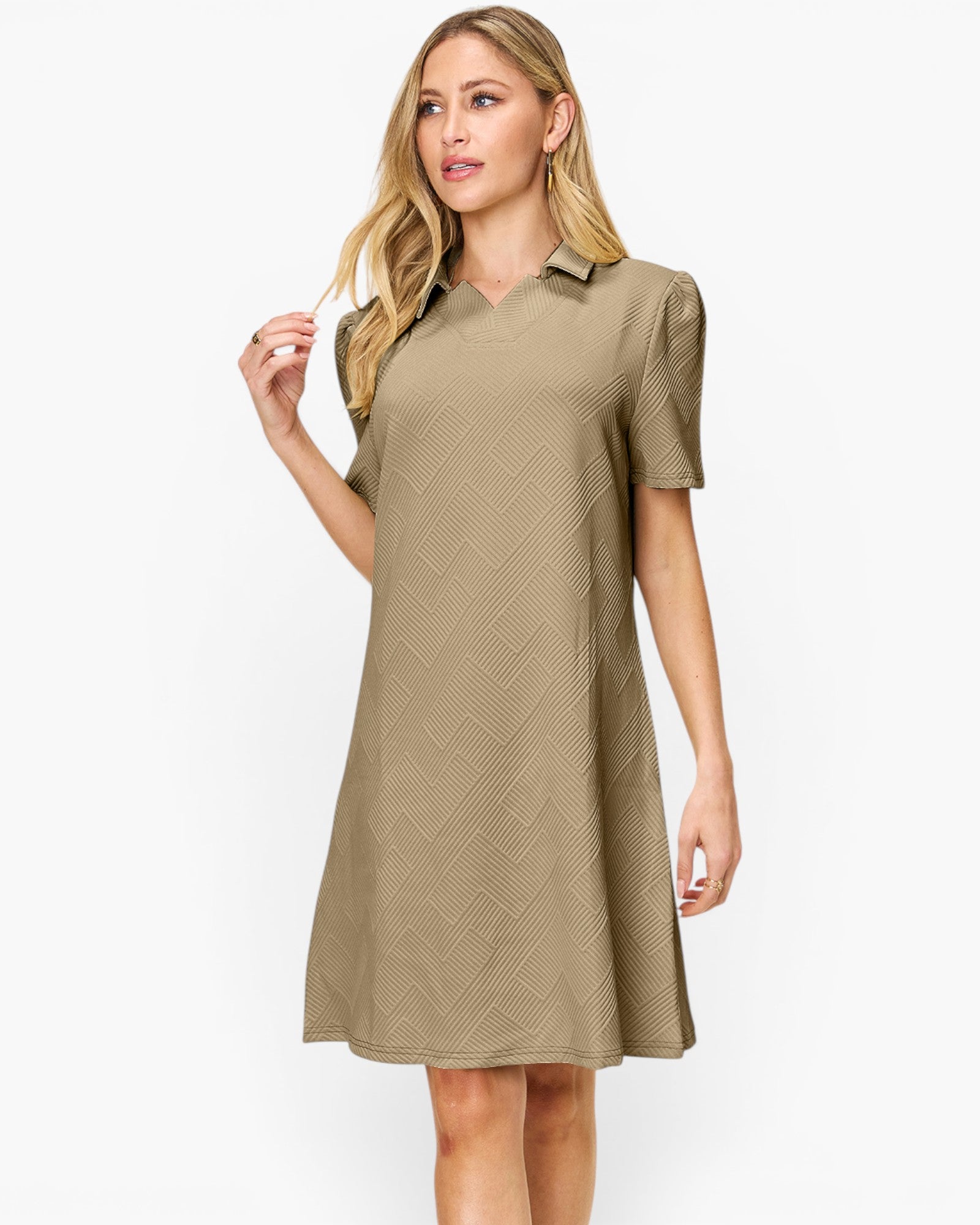 A woman modeling a short-sleeve collared shift dress in a warm khaki-beige color with a subtle textured chevron pattern, set against a plain white studio background.