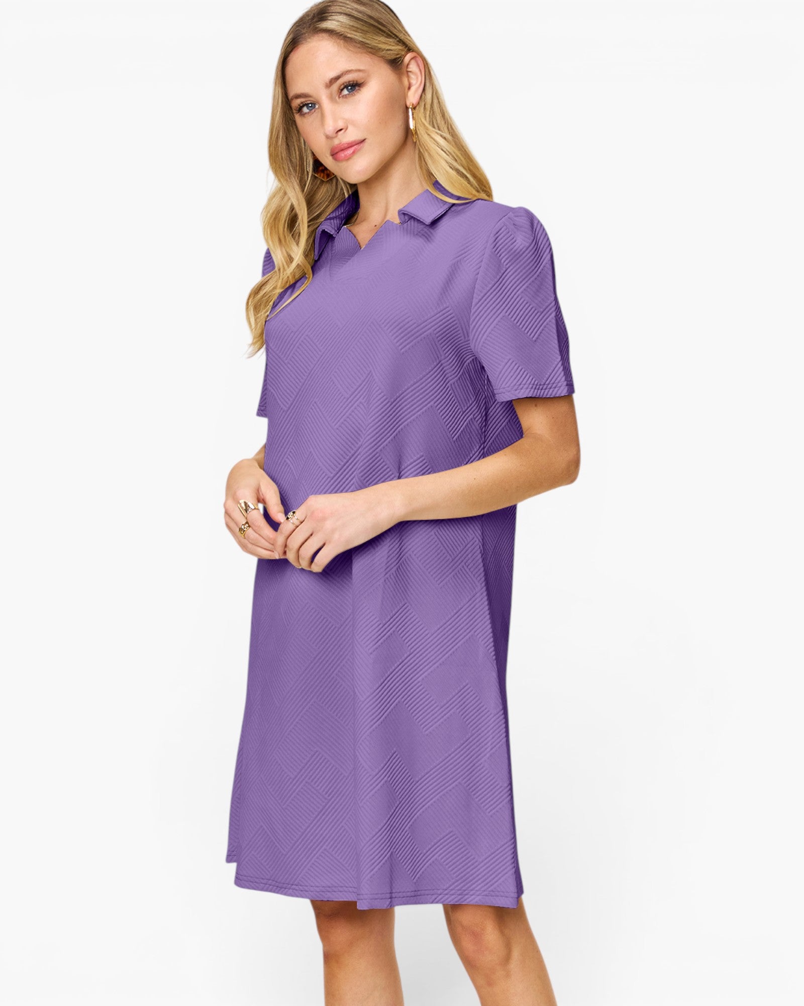 A woman modeling a short-sleeve purple collared shift dress with a subtle textured pattern, set against a plain white studio background.