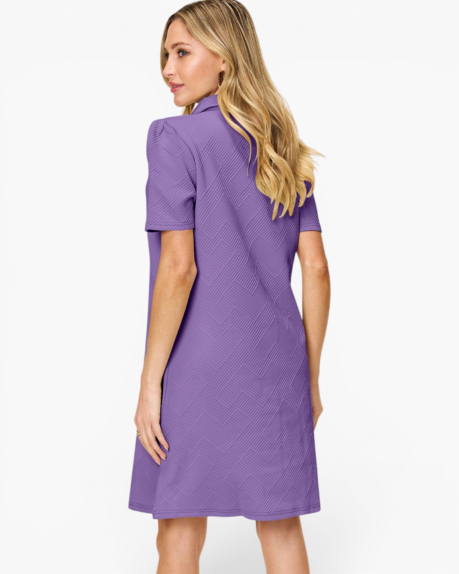 A woman modeling a short-sleeve purple dress from the back, featuring a textured geometric pattern and a high mock neck, against a plain white background.