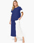 A woman modeling a color-blocked short-sleeve top and matching wide-leg pants set. The top has a navy blue body with white sleeves, and the pants are split down the middle with navy on one leg and white on the other.