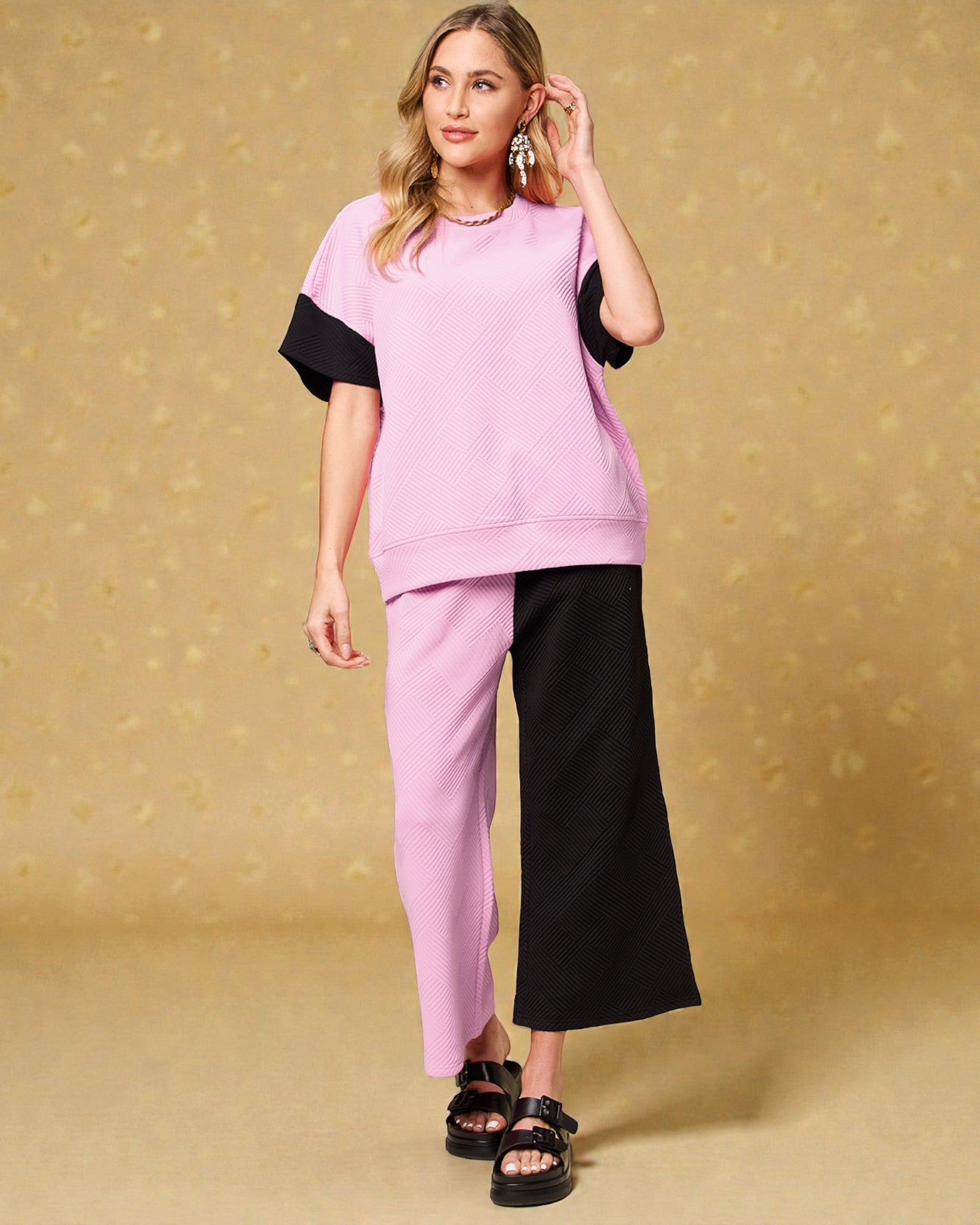 Woman wearing a pink and black outfit on a beige background