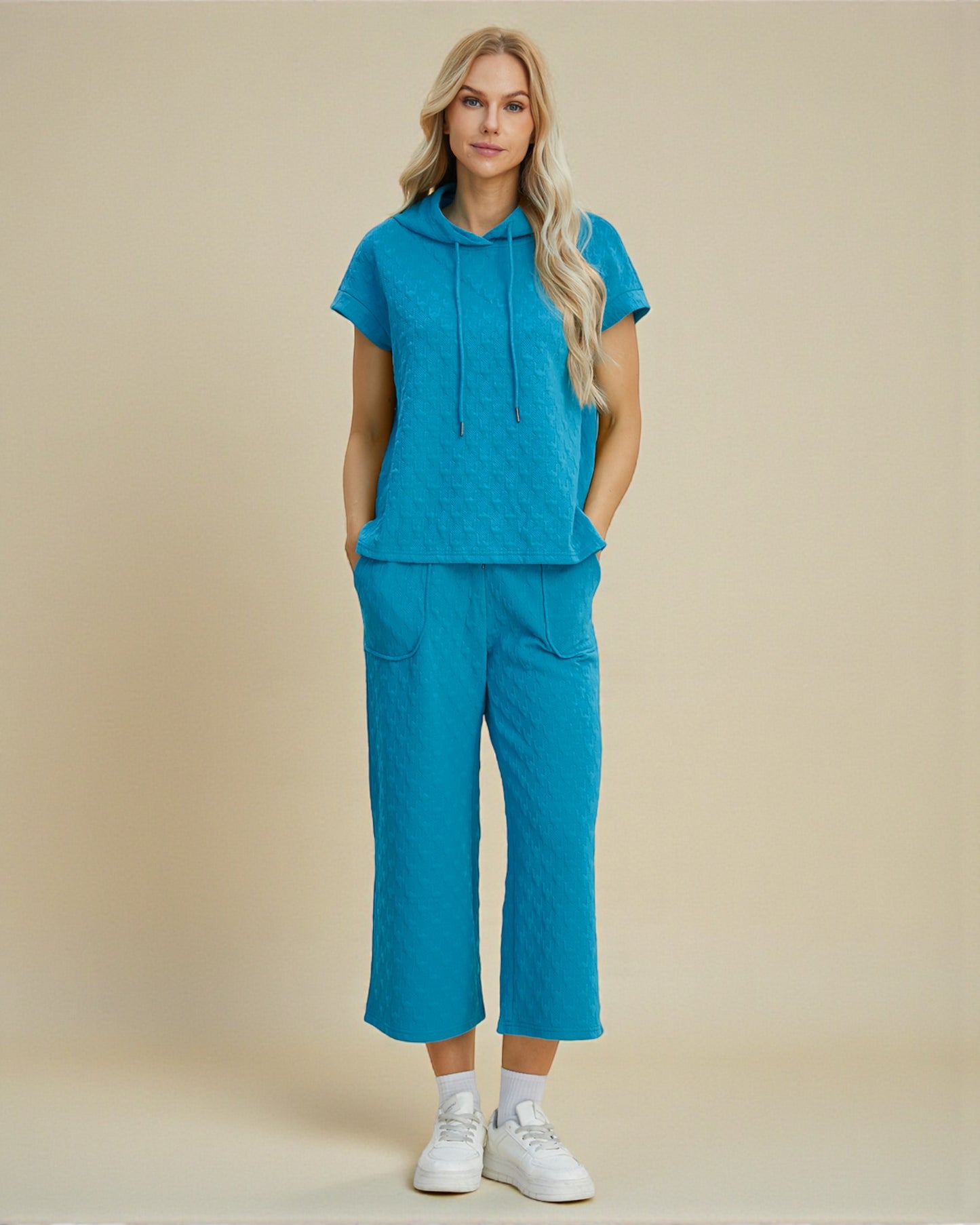 Woman wearing a blue outfit with a beige background