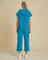 Person wearing a blue tracksuit against a beige background