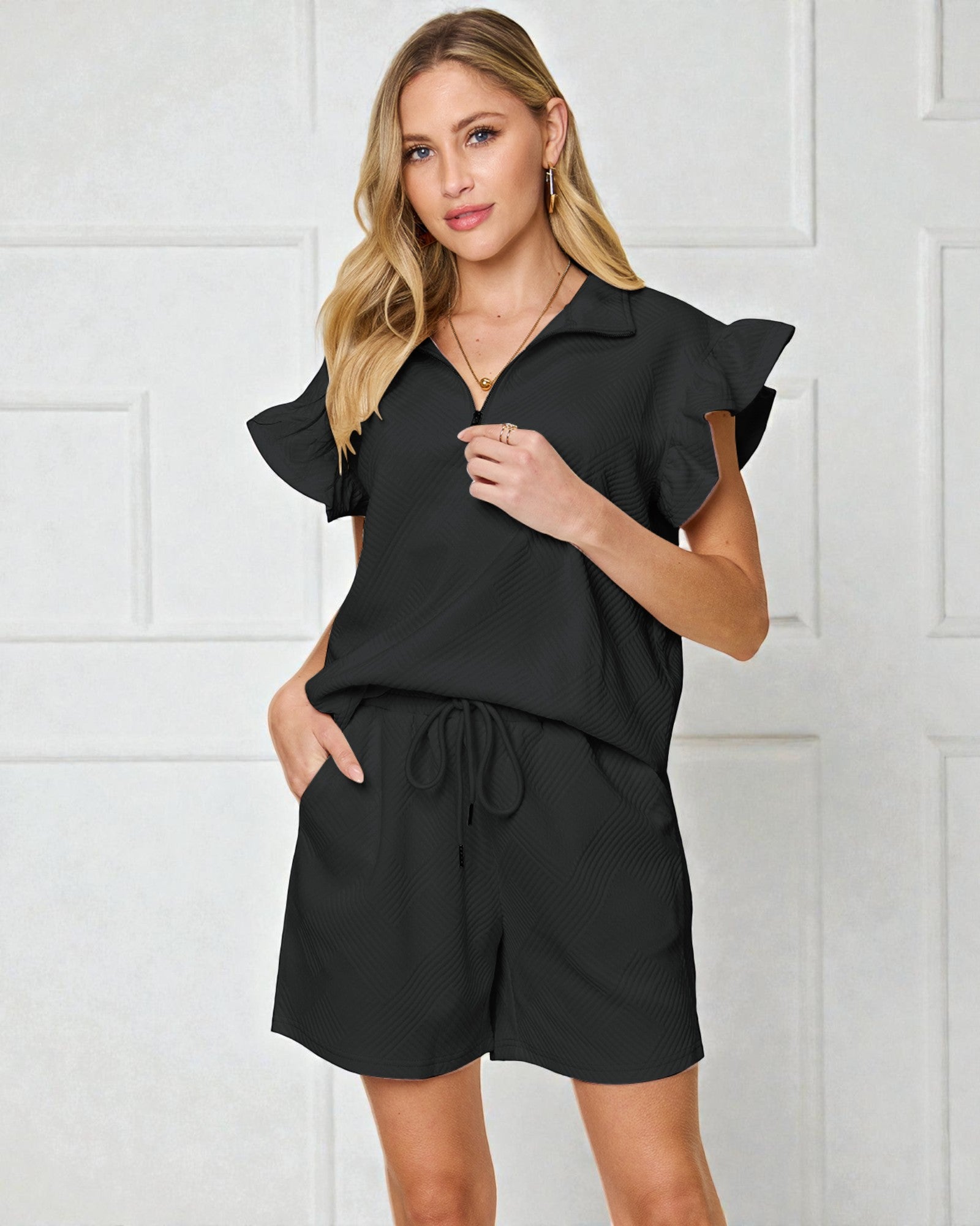Woman wearing a black romper against a white background