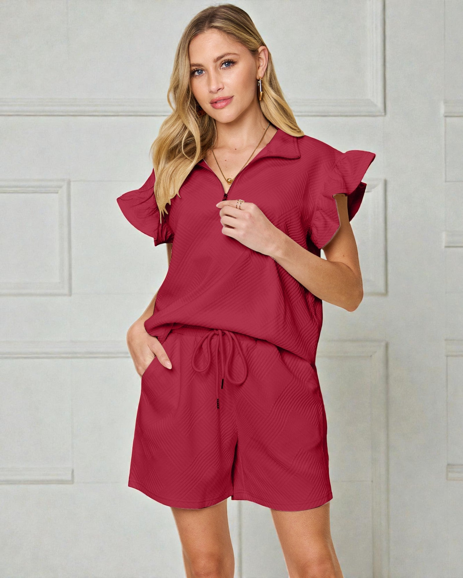 Woman wearing a red outfit with ruffled sleeves on a beige background