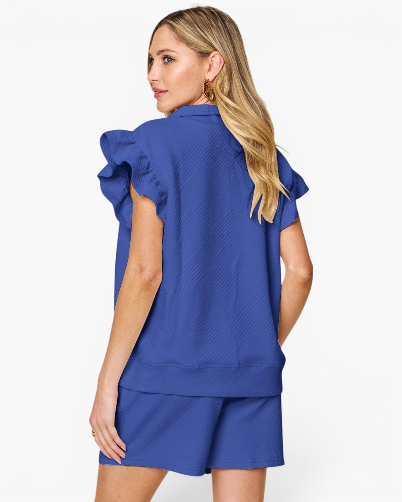 A woman shown from the back wearing a matching royal blue textured top and shorts set, featuring ruffled short sleeves on the top, against a plain white studio background.