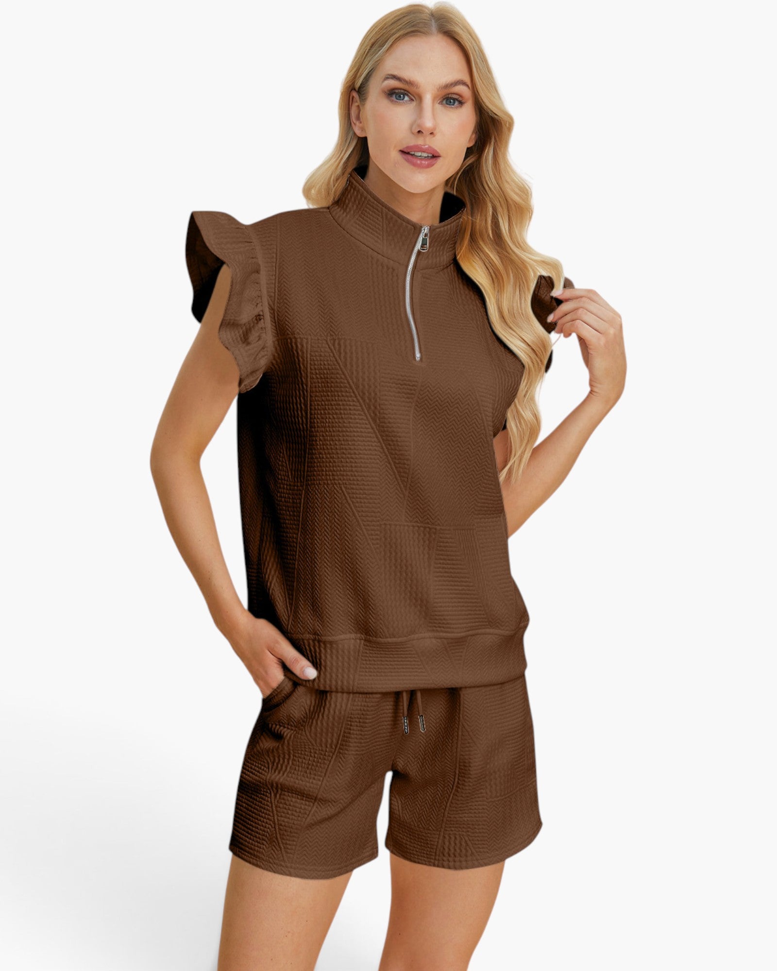 A woman modeling a brown textured two-piece lounge set featuring a sleeveless quarter-zip top with ruffled shoulder details and matching drawstring shorts, set against a plain white background.