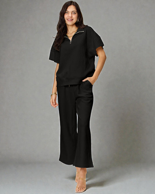 Woman wearing a black outfit against a gray background