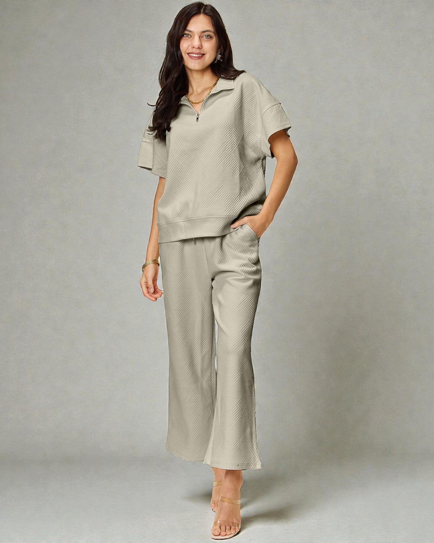 Woman wearing a beige outfit with a plain background