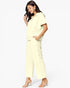 A woman modeling a pale yellow short-sleeve collared top and matching wide-leg cropped pants against a plain white studio background.