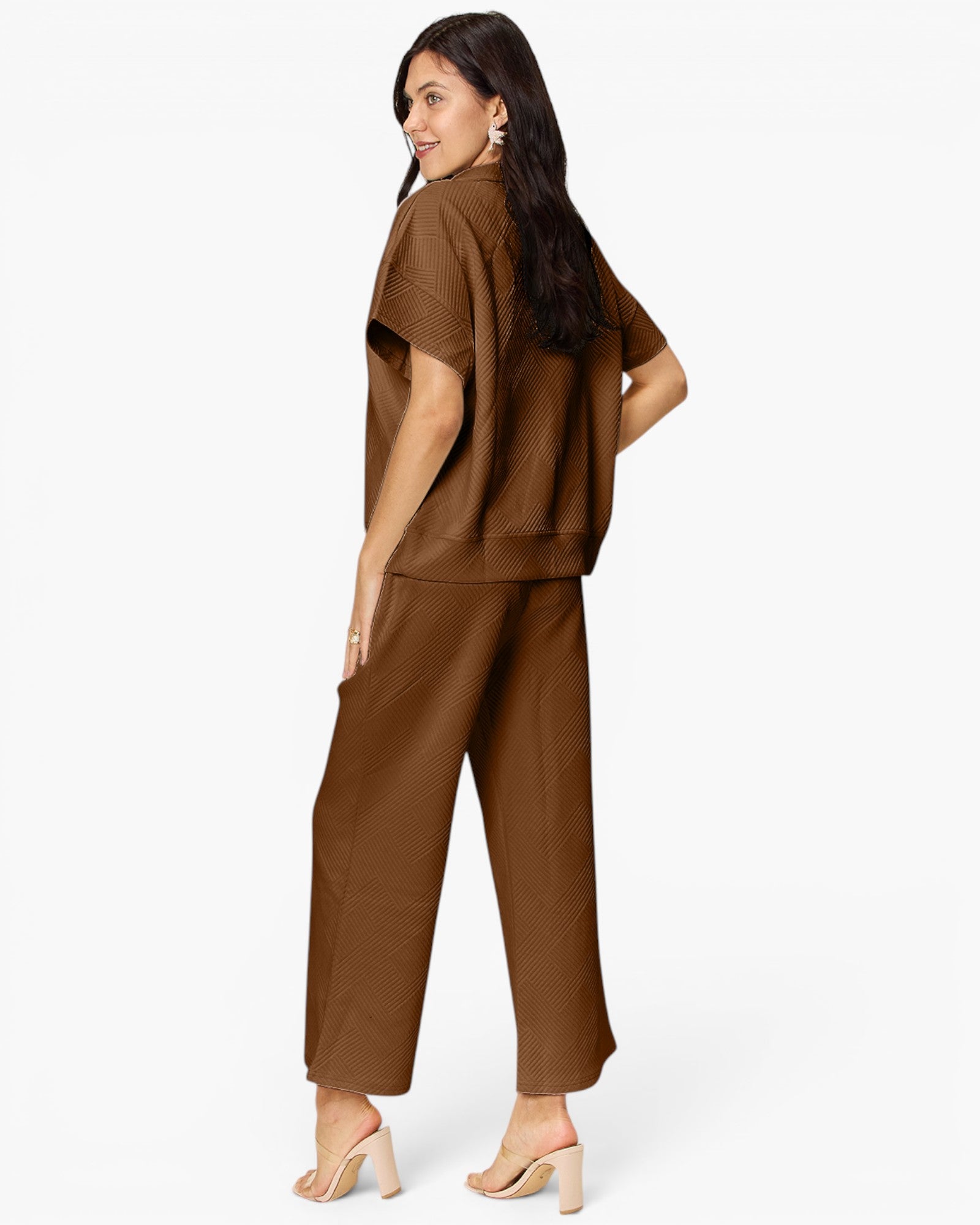 A woman modeling a matching brown two-piece outfit consisting of a short-sleeve cropped top and wide-leg cropped pants, shown from a three-quarters back view against a plain white background.