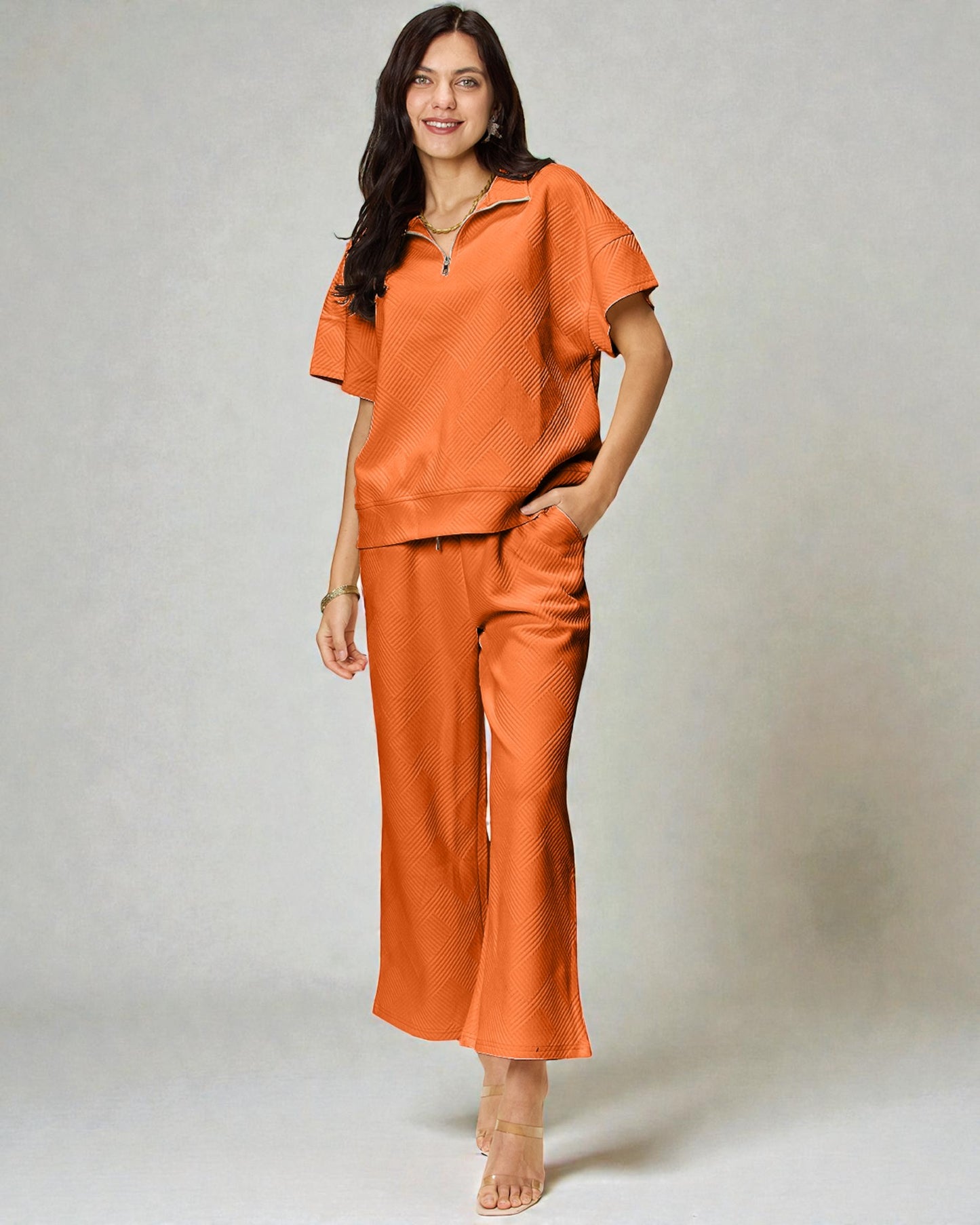 Woman wearing an orange outfit with a plain background