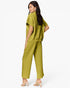 A woman modeling a matching two-piece olive green set consisting of a short-sleeve cropped top and wide-leg cropped pants, shown from a three-quarters back view against a plain white studio background.