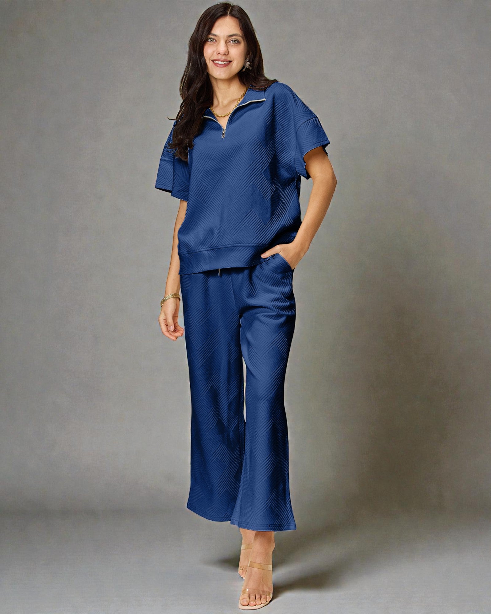 Woman wearing a blue outfit against a gray background