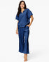 A woman modeling a matching two-piece lounge set in a rich royal blue color. The set includes a short-sleeve mock-neck top with a subtle textured pattern and matching wide-leg pants, photographed against a clean white studio background.
