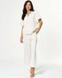 Woman wearing a white outfit on a plain background