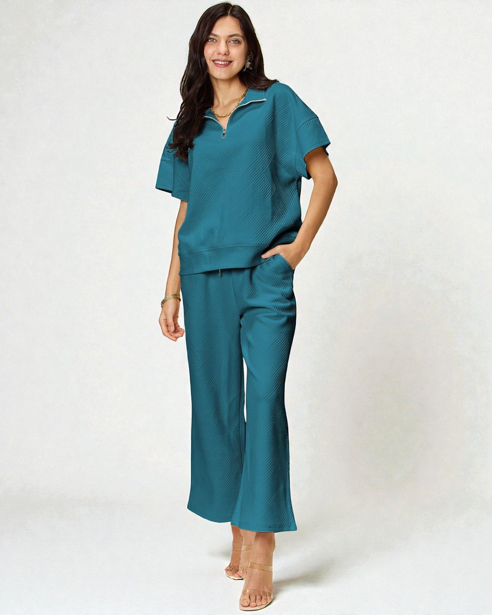 Woman wearing a teal outfit on a white background